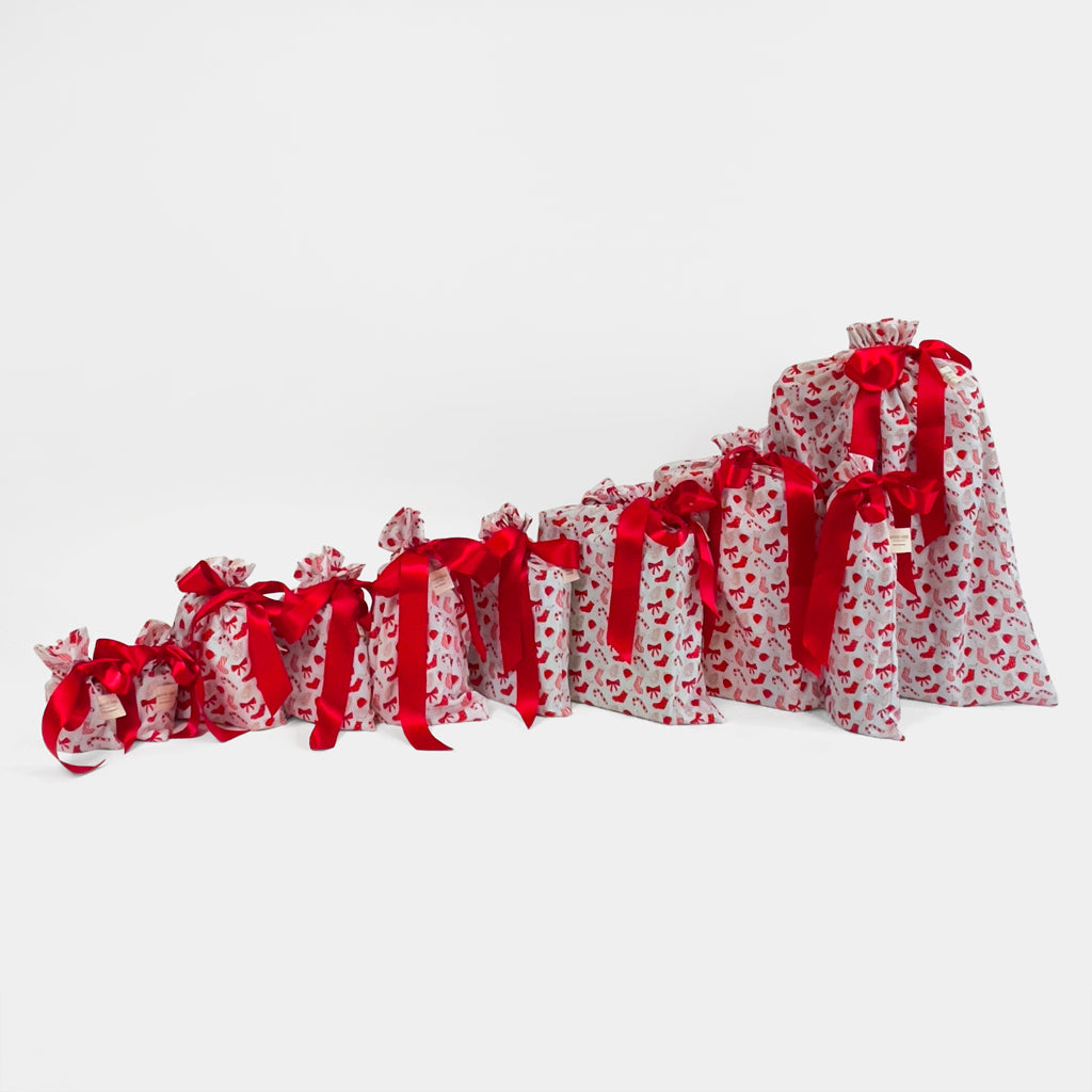 Set of 10 reusable gift bags, including a santa sack. Traditional red and white design with christmas cookies and candy.