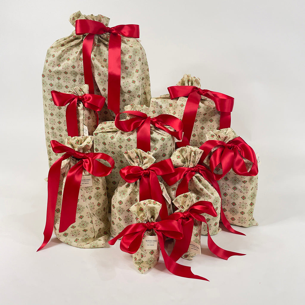 Set of 10 reusable gift bags including huge santa sack. In a nordic folk art geometric pattern with a red bow.