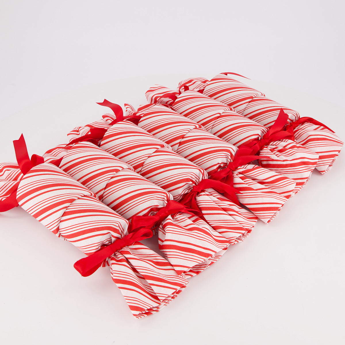 Candy Cane reusable Christmas crackers — 6 crackers unboxed in a row — bold red & white stripe fabric — handmade in Afghanistan