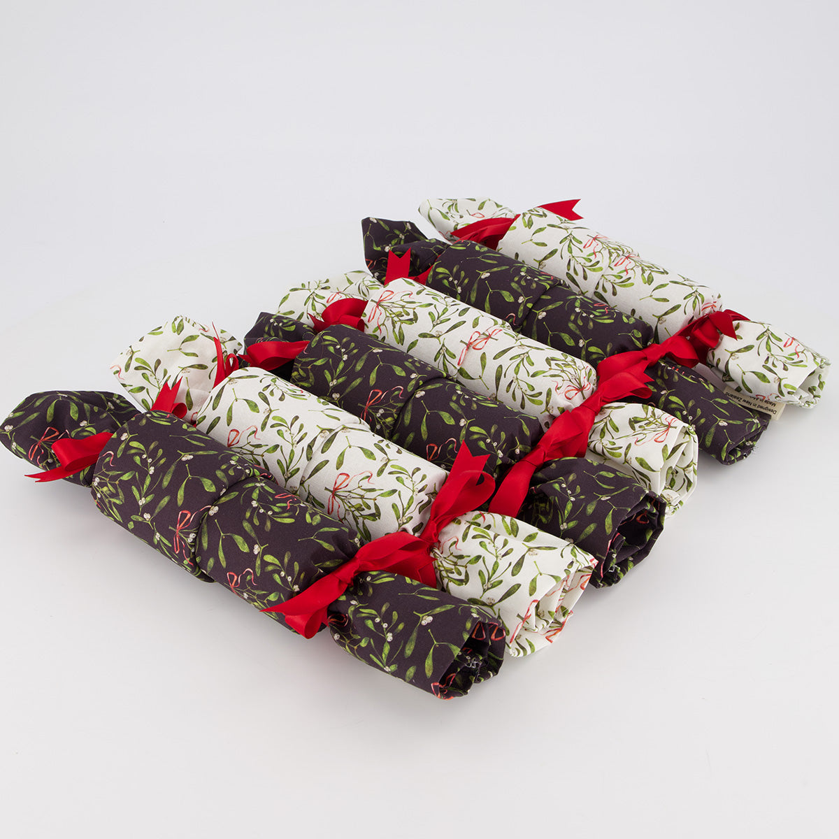 Mistletoe reusable Christmas crackers — 6 crackers unboxed in a row — mistletoe & berries on black & white fabric — handmade in Afghanistan