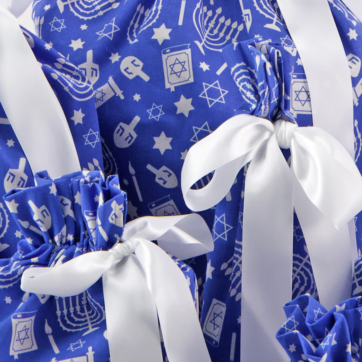 Hanukkah fabric close-up — menorah and Star of David print in white on cobalt blue