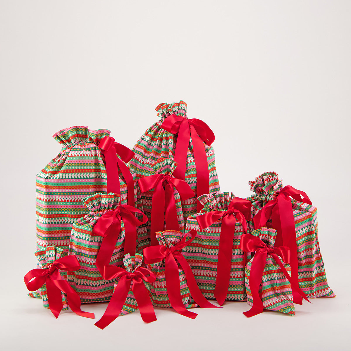 Fiesta reusable gift bag set of 10 — bold geometric stripe print in red, pink, green and gold — handmade in Afghanistan