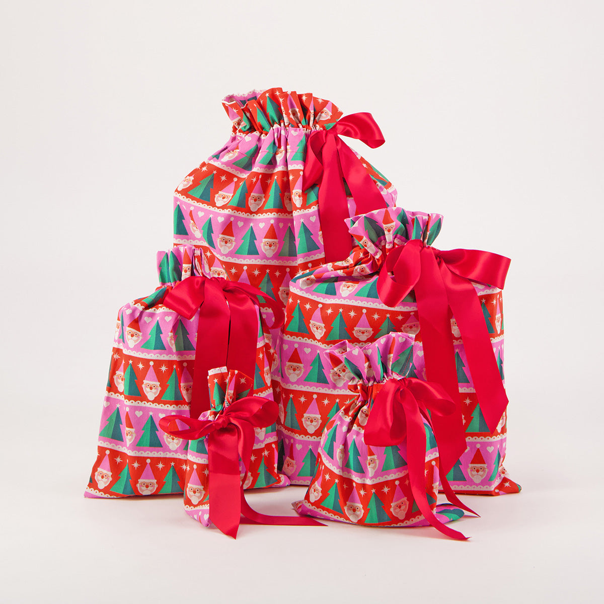 Papa Noel reusable gift bag set of 5 — Santa and Christmas tree print in bold pink, red and green — handmade in Afghanistan